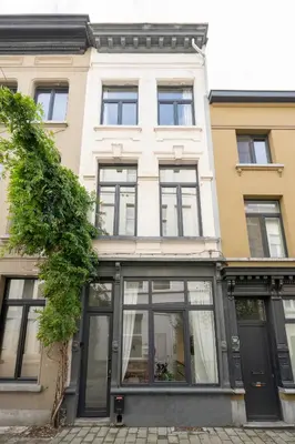 a building with glass windows and a tree in front of it at SHWAY - The Saffron Dress in Antwerp