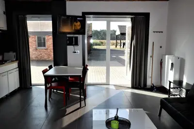 a kitchen and living room with a table and chairs at Hoeve Megusta in Vlimmeren