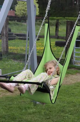 a little girl is sitting in a swing at Hoeve Megusta in Vlimmeren