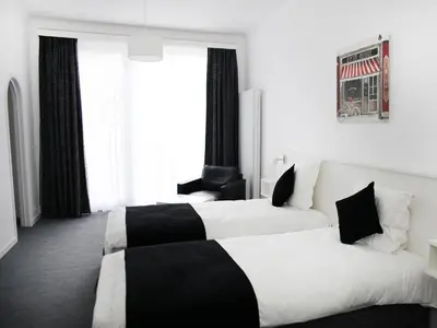 two beds in a hotel room with black and white at Hotel Satellite in Brussels