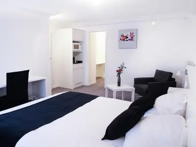 a bedroom with a black and white bed and a chair at Hotel Satellite in Brussels