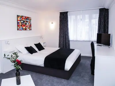 a hotel room with a bed and a tv at Hotel Satellite in Brussels