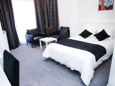 a bedroom with a large bed and two chairs at Hotel Satellite in Brussels