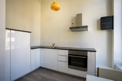 a kitchen with white cabinets and a stove top oven at Nice furnished appartement AAA- location in Antwerp