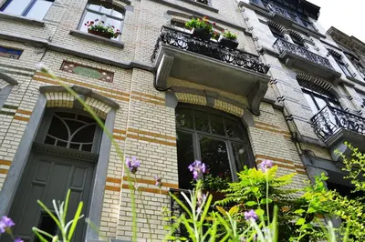 a brick house with windows and flowers on it at Villa des Roses Voltaire in Brussels