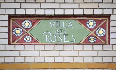 a sign that says villa des roses on a brick wall at Villa des Roses Voltaire in Brussels