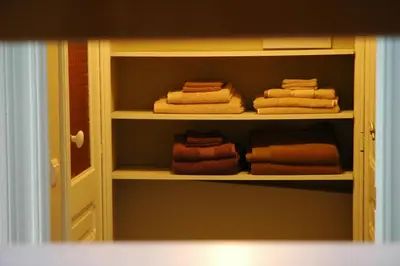 a closet with towels and folded towels on shelves at Villa des Roses Voltaire in Brussels