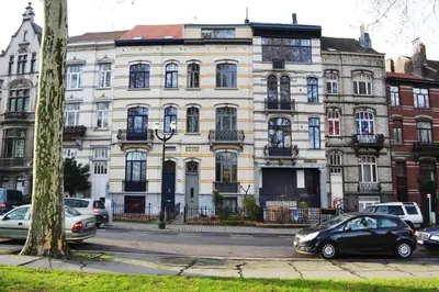 a large white building with cars parked in front of it at Villa des Roses Voltaire in Brussels