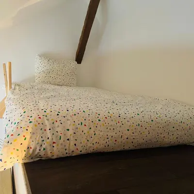 a bed with a polka dot bedspread with dots on it at Charming Loft in Prime Location in Brussels