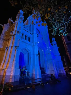 a building lit up in blue at night at Charming Loft in Prime Location in Brussels