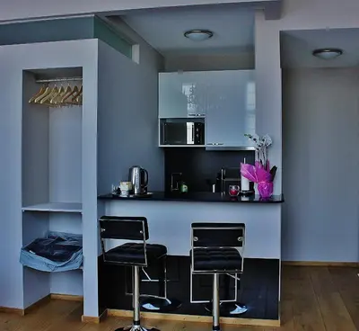 a kitchen with a bar with two stools in it at B&B Avenue Deschanel in Brussels