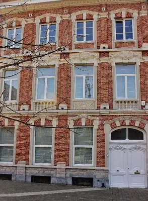 a brick building with a white door and windows at B&B Avenue Deschanel in Brussels