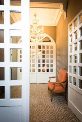 a room with a door and a chair and a chandelier at B&B Avenue Deschanel in Brussels