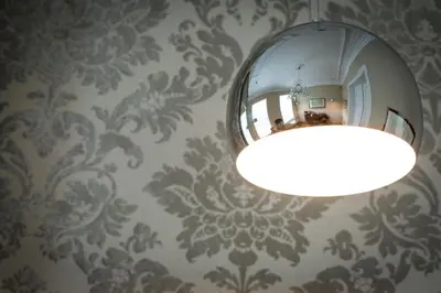 a bathroom with a mirror and a light on a wall at B&B Avenue Deschanel in Brussels