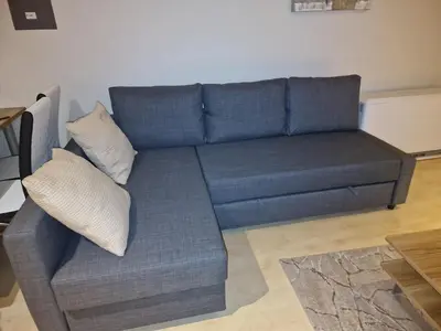a blue couch with two pillows in a living room at Garden Botanique Apartment in Brussels