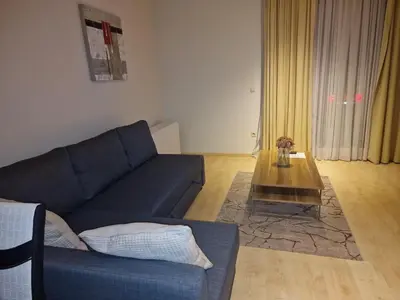 a living room with a blue couch and a coffee table at Garden Botanique Apartment in Brussels