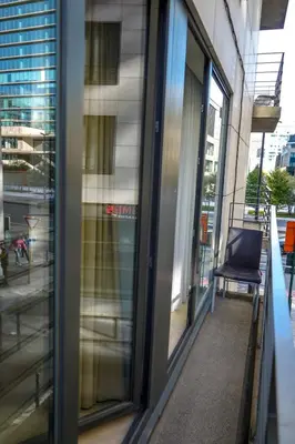 a balcony with glass doors and a chair in a building at Garden Botanique Apartment in Brussels