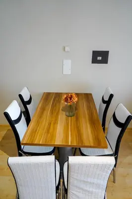 a wooden table with chairs and a pizza on it at Garden Botanique Apartment in Brussels