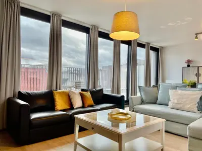 a living room with a couch and a table at OneLuxStay near Diamond District in Antwerp