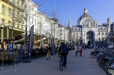 a man riding a bike down a city street at OneLuxStay near Diamond District in Antwerp