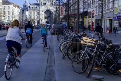 a group of people riding bikes on a city street at OneLuxStay near Diamond District in Antwerp