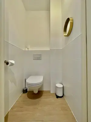 a white bathroom with a toilet in a room at OneLuxStay near Diamond District in Antwerp