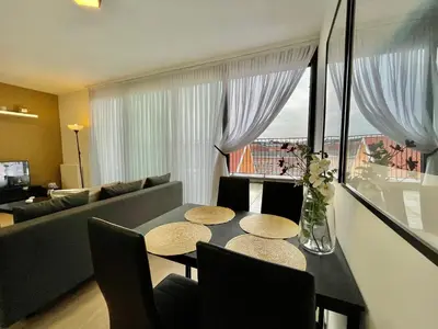 a living room with a table with chairs and a couch at OneLuxStay near Diamond District in Antwerp