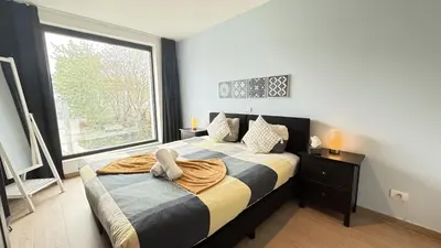 a bedroom with a bed with a large window at OneLuxStay near Diamond District in Antwerp