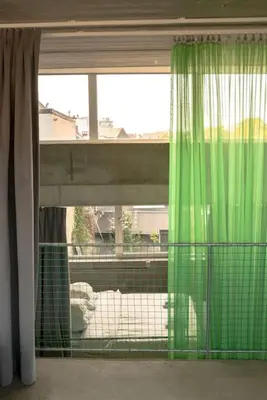 a green curtain in a room with a window at Mari's: Multifunctional Shelter with big Garden in Ghent