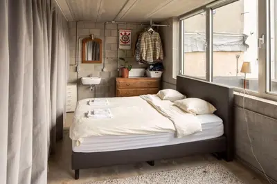 a small bedroom with a bed and a window at Mari's: Multifunctional Shelter with big Garden in Ghent