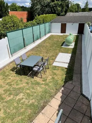 a backyard with a table and chairs and a vase at Cosy flat for 4 p. with garden in Tremelo in Tremelo