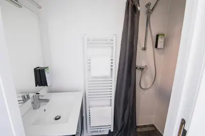 a bathroom with a shower with a sink and a toilet at TravelEase - Midi in Brussels
