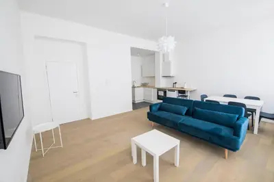 a living room with a blue couch and a table at TravelEase - Midi in Brussels