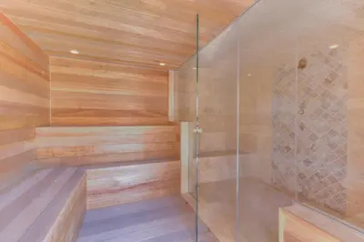 a sauna with wooden walls and a glass shower stall at Cap d'Eau in Waasmunster