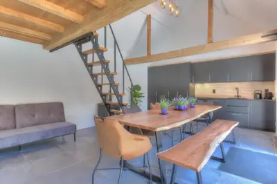a kitchen and dining room with a wooden table and chairs at Cap d'Eau in Waasmunster