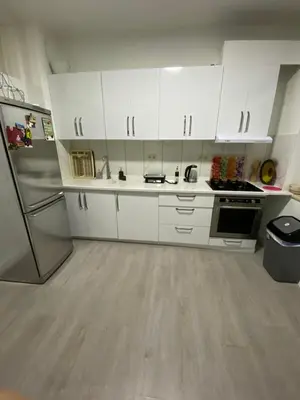 a kitchen with white cabinets and a refrigerator at Appartement Deux chambres près de Atomium in Brussels