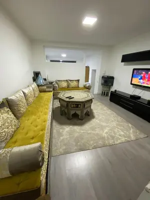a living room with a yellow couch and a table at Appartement Deux chambres près de Atomium in Brussels