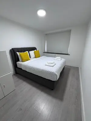 a bedroom with a bed with yellow pillows at Appartement Deux chambres près de Atomium in Brussels