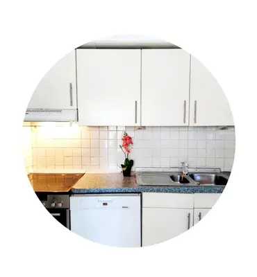 a white kitchen with white cabinets and a sink at Belle chambre dans un quartier calme in Brussels