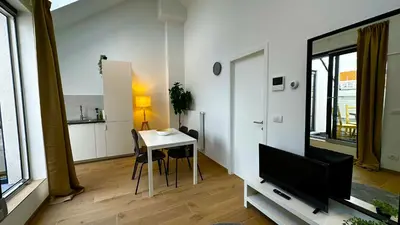 a living room with a table and a tv at OneLuxStay near Fashion District in Antwerp