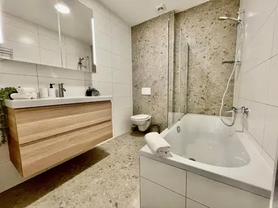 a bathroom with a tub and a sink and a toilet at OneLuxStay near Fashion District in Antwerp