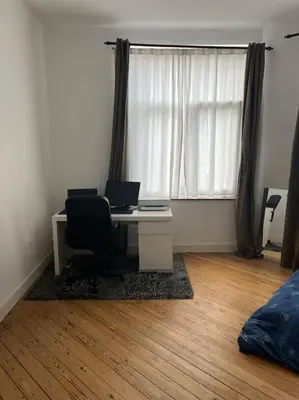 a room with a desk with a computer and a window at L Escapade Urbaine in Brussels
