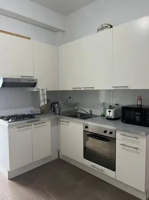 a kitchen with white cabinets and a stove top oven at L Escapade Urbaine in Brussels