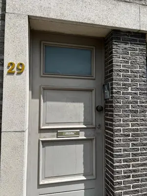 a door in a brick building with the number twenty at Appartement29 in Wetteren