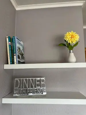 a shelf with a vase with a yellow flower and books at Appartement29 in Wetteren