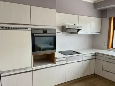 a kitchen with white cabinets and a stove top oven at Appartement29 in Wetteren