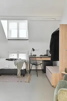 a bedroom with a bed and a desk and a chair at B&B Vossebergen Hombeek in Hombeek