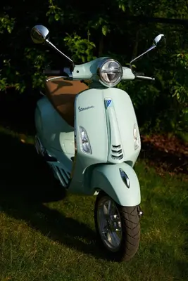 a scooter parked on the grass in a field at B&B Vossebergen Hombeek in Hombeek