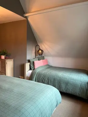 a bedroom with two beds and a lamp at Sfeervol familielandhuis in de groene Kempen in Baarle-Hertog