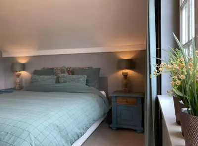 a bedroom with a bed and a table and lamps at Sfeervol familielandhuis in de groene Kempen in Baarle-Hertog